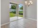 Open dining area features tile flooring, sliding glass doors, and modern light fixture at 928 Pearlwood Loop, Eagle Lake, FL 33839