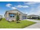 Attractive one-story home featuring a gray garage door, stone facade, and lush green lawn in a modern residential neighborhood at 928 Pearlwood Loop, Eagle Lake, FL 33839
