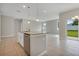Kitchen island with granite countertops, stainless steel appliances, pendant lighting and view to living room at 928 Pearlwood Loop, Eagle Lake, FL 33839