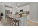 Well-lit kitchen with stainless appliances, white cabinets, tile floor, and barstool seating at 928 Pearlwood Loop, Eagle Lake, FL 33839
