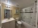 Cozy bathroom featuring a shower-tub combo with sliding glass doors, single sink vanity, and neutral wall color at 1000 S Semoran Blvd # 608, Winter Park, FL 32792