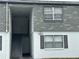 Building exterior featuring gray shingles, white paint, and an entryway with staircase to upper units at 1000 S Semoran Blvd # 608, Winter Park, FL 32792