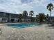 Community pool with lounge chairs, set amongst manicured grounds and palm trees at 1000 S Semoran Blvd # 608, Winter Park, FL 32792