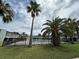 View of a fenced in community pool surrounded by palm trees and green grass at 1000 S Semoran Blvd # 608, Winter Park, FL 32792