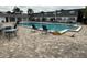 Community pool with chairs and tables, surrounded by a brick paved deck at 1000 S Semoran Blvd # 608, Winter Park, FL 32792