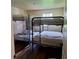 Bedroom with three metal-framed bunkbeds and wood floors at 10012 Lake Louisa Rd, Clermont, FL 34711