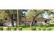 Charming single-story home with stone accents, a manicured lawn, and a welcoming two-car garage at 10012 Lake Louisa Rd, Clermont, FL 34711