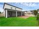 Spacious backyard features a screened lanai, brick patio, and lush green lawn perfect for outdoor enjoyment at 10078 Hampshire Oaks Dr, Orlando, FL 32825
