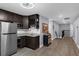 Basement kitchenette with dark cabinets, stainless steel fridge, and open floorplan at 10078 Hampshire Oaks Dr, Orlando, FL 32825