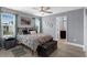 Cozy bedroom with wood floors, ceiling fan, large windows, and a door to the bathroom at 10078 Hampshire Oaks Dr, Orlando, FL 32825