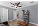 Well-lit spare bedroom with ceiling fan, decorative shelving, and light wood flooring at 10078 Hampshire Oaks Dr, Orlando, FL 32825