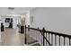 Upstairs hallway with wood flooring, decorative staircase, and light gray walls at 10078 Hampshire Oaks Dr, Orlando, FL 32825