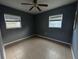 Cozy bedroom featuring tile flooring, two bright windows, and a modern ceiling fan at 102 Luna Rd, Auburndale, FL 33823