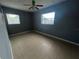 Spacious bedroom with neutral tile flooring, two bright windows, and a colorful ceiling fan at 102 Luna Rd, Auburndale, FL 33823