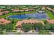 Stunning aerial view of community featuring a serene lake, pool, lush greenery, and well-maintained townhome exteriors at 10308 Belfry Cir, Orlando, FL 32832