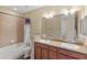 Bathroom features double sink vanity with granite countertops and tub with shower at 10308 Belfry Cir, Orlando, FL 32832