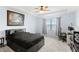 The bedroom has a tray ceiling, ceiling fan, window, and a black bed frame with carpet floors at 10308 Belfry Cir, Orlando, FL 32832