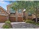 Exterior view of townhome with stone accents and three-car garage at 10308 Belfry Cir, Orlando, FL 32832