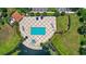 Aerial view of neighborhood pool with lake backdrop and lounge seating at 10308 Belfry Cir, Orlando, FL 32832