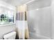 Clean bathroom features white tile and a shower tub combo with curtain at 1126 Villa Ln # 91, Apopka, FL 32712