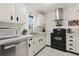 A bright kitchen featuring white cabinets, a window and modern appliances including a black oven and stainless dishwasher at 1126 Villa Ln # 91, Apopka, FL 32712