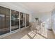 Enclosed patio features a table and chairs; the sliding glass doors reflect an interior view at 1126 Villa Ln # 91, Apopka, FL 32712