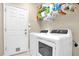 This laundry room boasts a washer, dryer, wire shelving, and a door leading to the exterior at 1171 Lebanon Ct, Sanford, FL 32771
