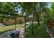 Lush backyard featuring a pergola, stone pathway, mature landscaping, and screened-in patio at 140 Seville Chase Dr, Winter Springs, FL 32708