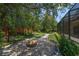 Beautiful backyard showing a stone fire pit, stepping stone walkway, mature trees, and screened lanai at 140 Seville Chase Dr, Winter Springs, FL 32708