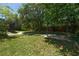 Expansive backyard featuring a lush lawn, mature trees, stepping stone paths, a pergola, and a screened-in patio at 140 Seville Chase Dr, Winter Springs, FL 32708