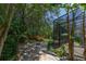 Lush backyard featuring a brick-paved patio with a fire pit surrounded by tropical foliage and wooden fencing at 140 Seville Chase Dr, Winter Springs, FL 32708