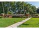 Entrance to Seville Chase featuring a brick entrance and lush landscaping at 140 Seville Chase Dr, Winter Springs, FL 32708