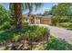 Inviting home featuring a brick driveway, two-car garage, lush landscaping, and an arched entryway at 140 Seville Chase Dr, Winter Springs, FL 32708