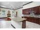 Gourmet kitchen with granite island, tile backsplash, and stainless steel appliances, open to the living room at 140 Seville Chase Dr, Winter Springs, FL 32708