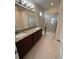 Bathroom features a dual sink vanity with granite counters and a glass shower at 15208 Avenue Of The Arbors, Winter Garden, FL 34787