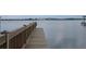 Picturesque view of a wooden dock extending into calm waters, offering a serene waterfront experience at 15208 Avenue Of The Arbors, Winter Garden, FL 34787