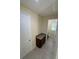 Hallway with granite-topped cabinet leading to a bathroom with tiled floors at 15208 Avenue Of The Arbors, Winter Garden, FL 34787