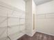 Walk-in closet with metal shelving units and a small mirror at 15208 Avenue Of The Arbors, Winter Garden, FL 34787