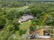 Expansive aerial view of the property showing the home, the additional garage, and a pond surrounded by lush greenery at 1550 Kevin Ln, Deland, FL 32724