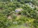 Overhead shot of the property surrounded by trees, featuring a pool and spacious layout at 1550 Kevin Ln, Deland, FL 32724