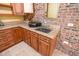 Close-up of wet bar with granite countertop and red brick accent wall at 1550 Kevin Ln, Deland, FL 32724