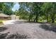Gravel driveway leading to a three-car garage with ample parking space at 1550 Kevin Ln, Deland, FL 32724