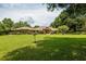 Expansive front yard leading to a charming brick home with a red front door at 1550 Kevin Ln, Deland, FL 32724