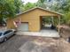 View of a large detached garage with carport and gravel driveway at 1550 Kevin Ln, Deland, FL 32724