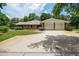 Attached three-car garage with mature landscaping and a concrete driveway at 1550 Kevin Ln, Deland, FL 32724