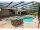 Screened-in pool with stone waterfall feature and surrounding brick patio at 1550 Kevin Ln, Deland, FL 32724