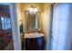 A powder room features a furniture vanity, decorator mirror and convenient access to the lanai at 1550 Kevin Ln, Deland, FL 32724