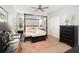 Spacious bedroom featuring a dark four-poster bed, neutral walls, and natural light from the window at 15606 Montesino Dr, Orlando, FL 32828