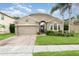 Charming single-story home boasts manicured lawn, mature landscaping, and a brick-paved driveway at 15606 Montesino Dr, Orlando, FL 32828