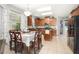 Eat-in kitchen featuring warm wood cabinetry, tile flooring, stainless appliances, and natural light at 15606 Montesino Dr, Orlando, FL 32828